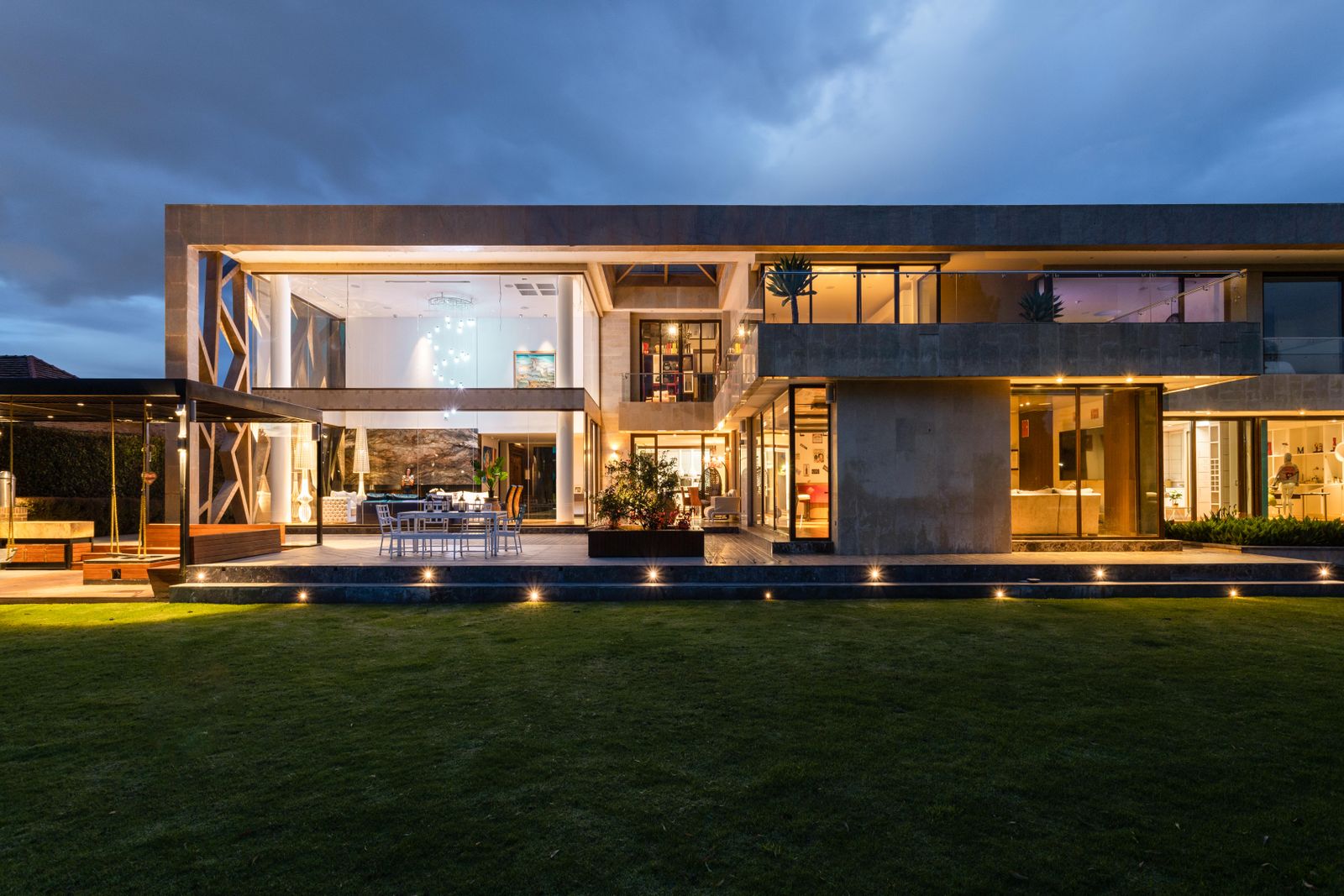 Geniş cam cepheli, sıcak ışıklarla aydınlatılmış modern villa
